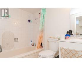 A bathroom with a white toilet, a bathtub, and a sink.