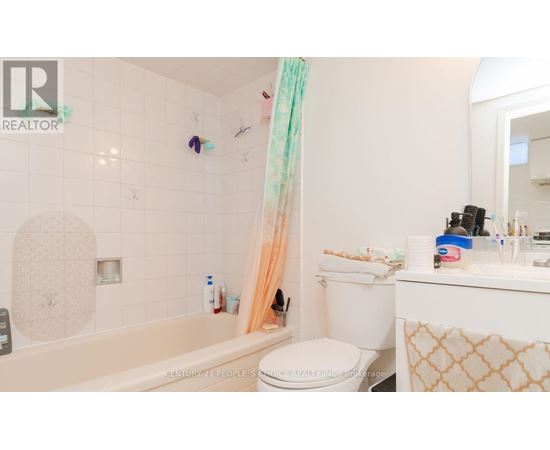 A bathroom with a white toilet, a bathtub, and a sink.