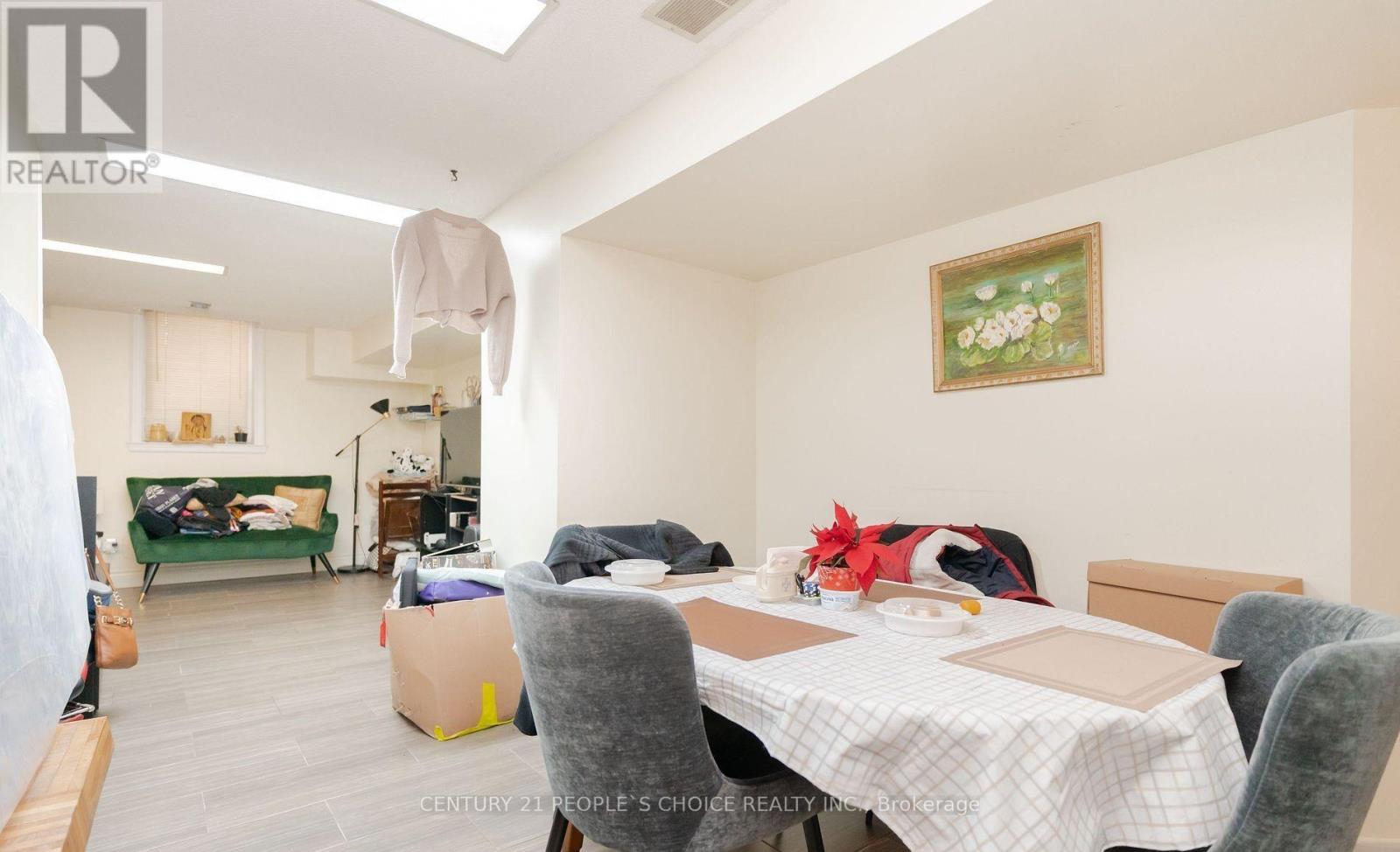 A room with a table, chairs and a painting on the wall.