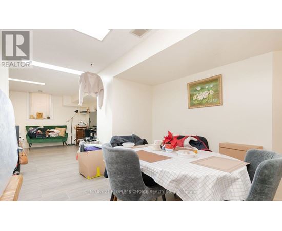 A room with a table, chairs and a painting on the wall.