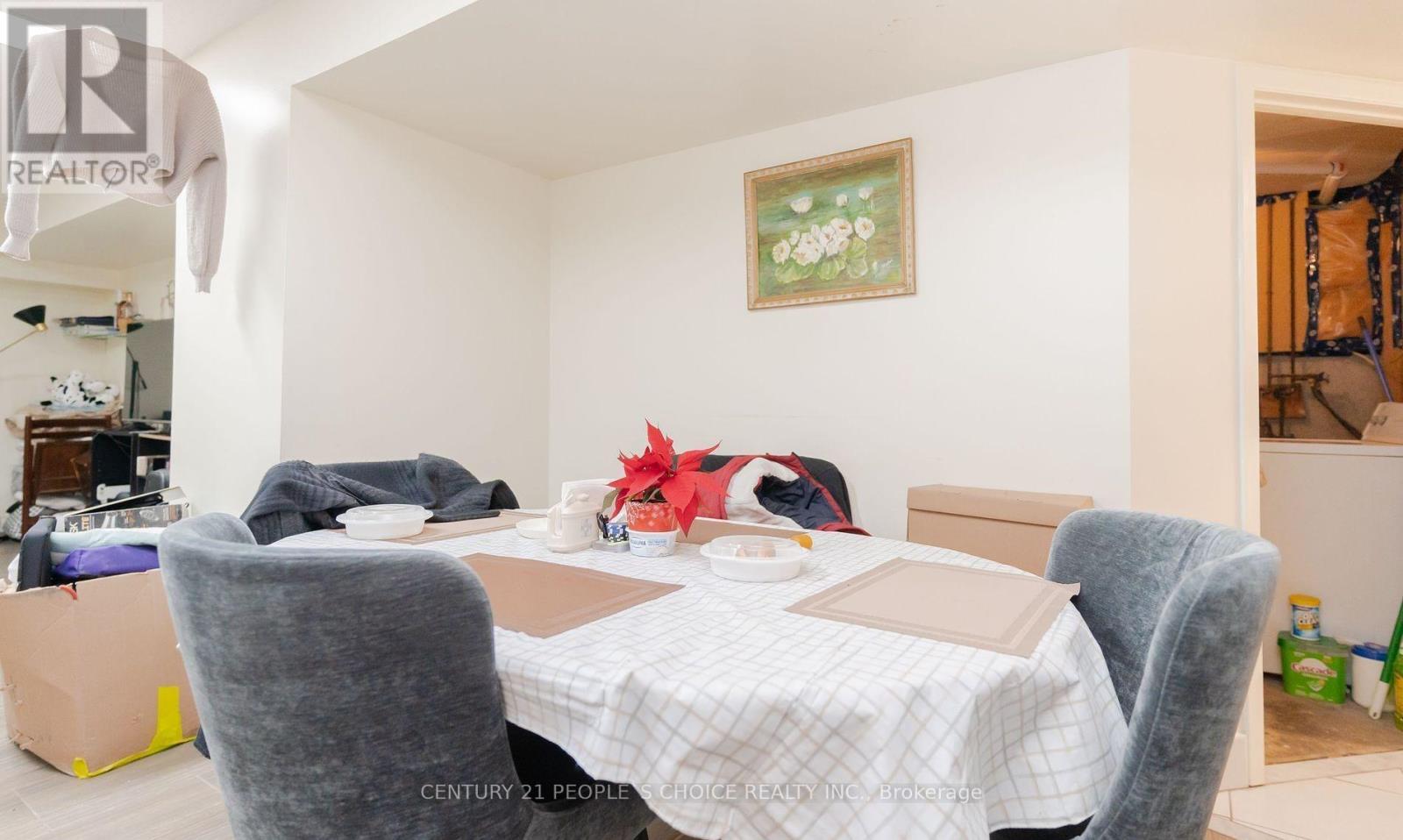 A dining room with a table set for two and a painting on the wall.
