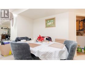 A dining room with a table set for two and a painting on the wall.