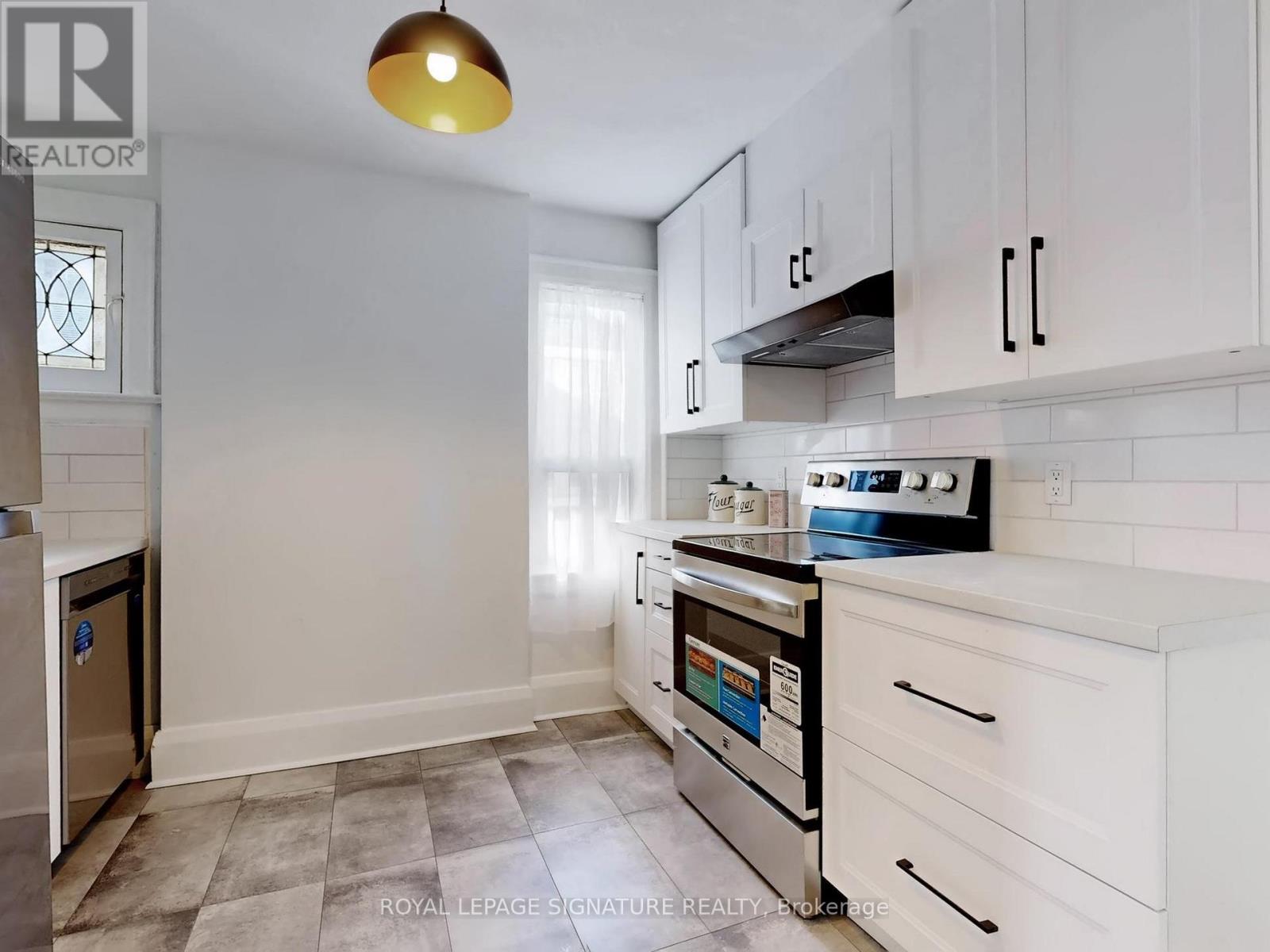A kitchen with white cabinets and a stainless steel dishwasher.