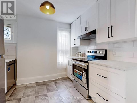 A kitchen with white cabinets and a stainless steel dishwasher.
