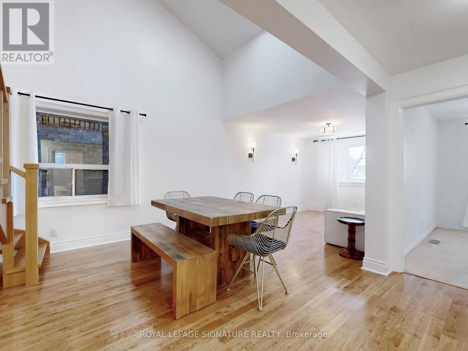 A dining room with a wooden table and chairs.