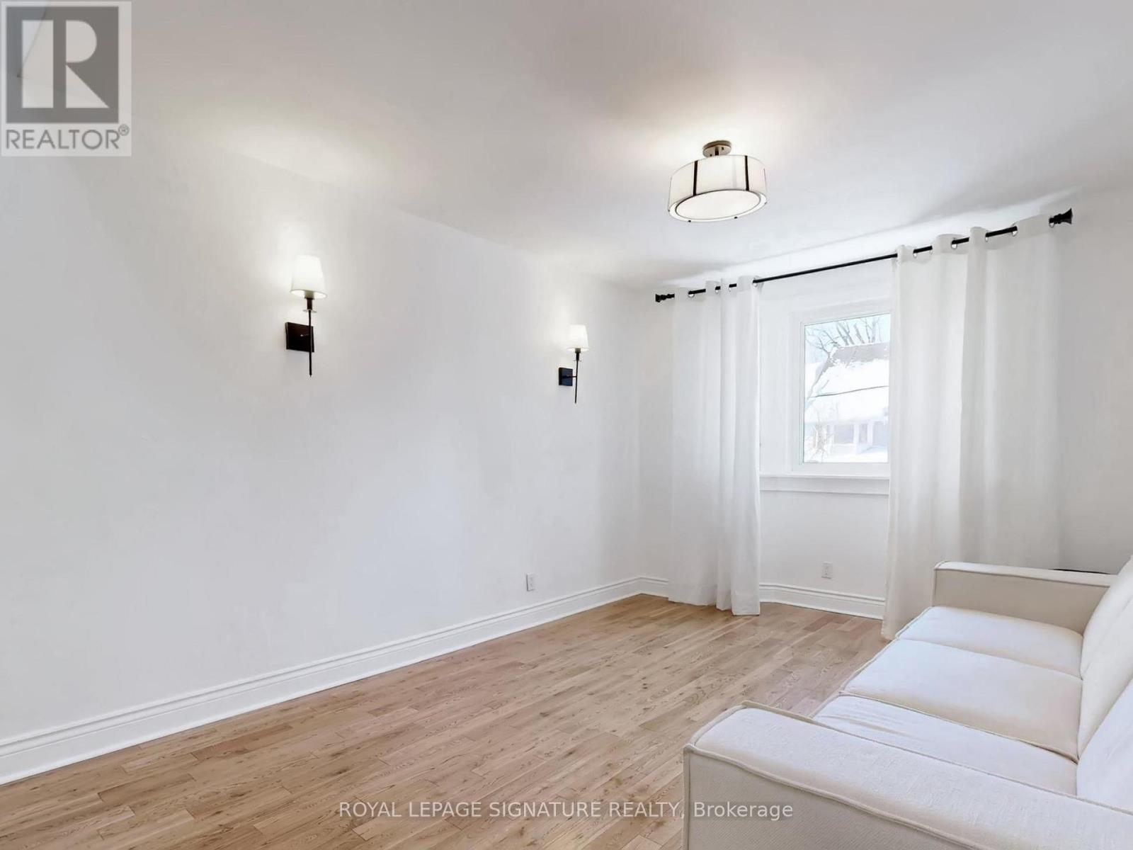 A white bedroom with a bed and a window.