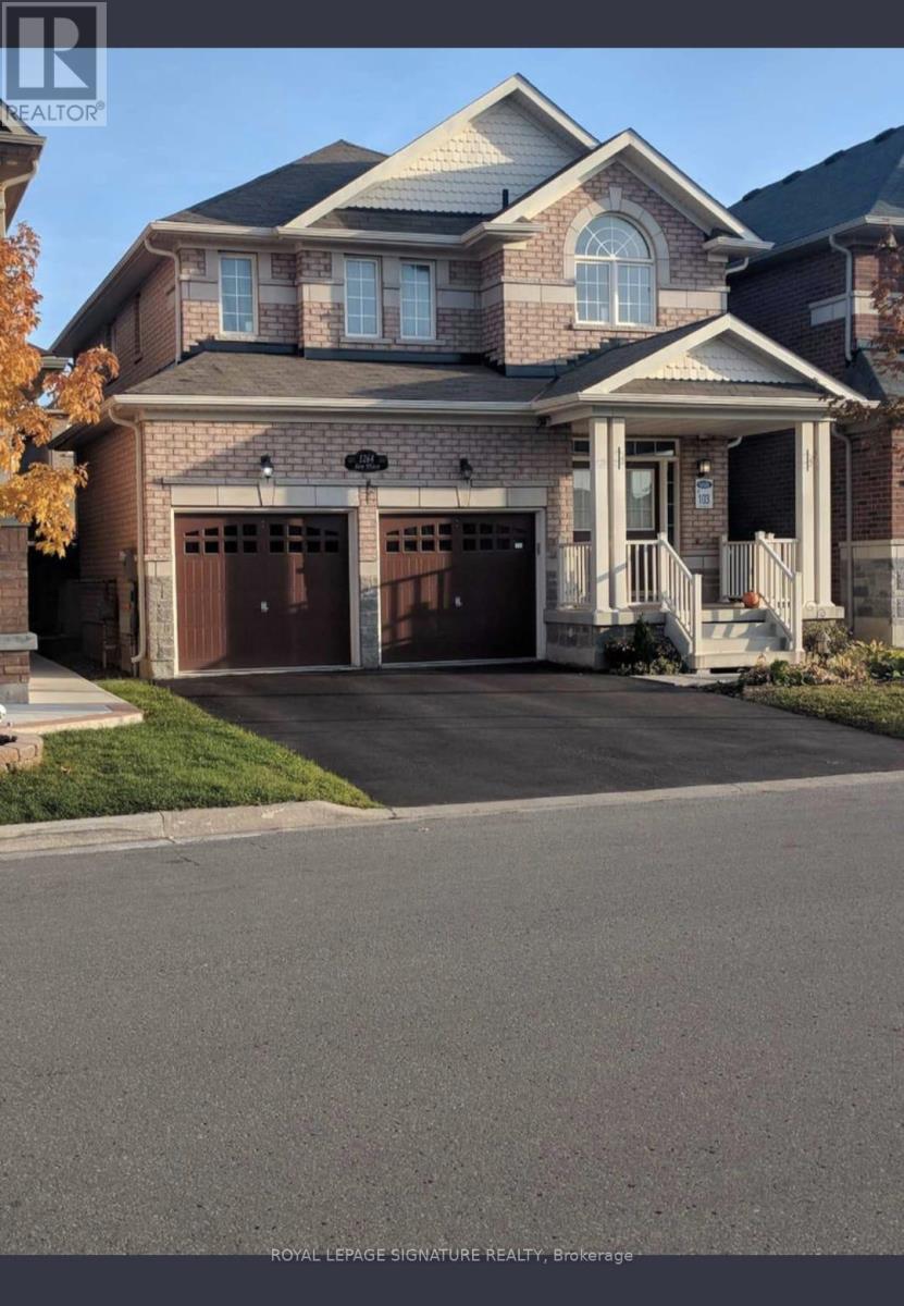 A large brick house with a garage and a driveway in front.
