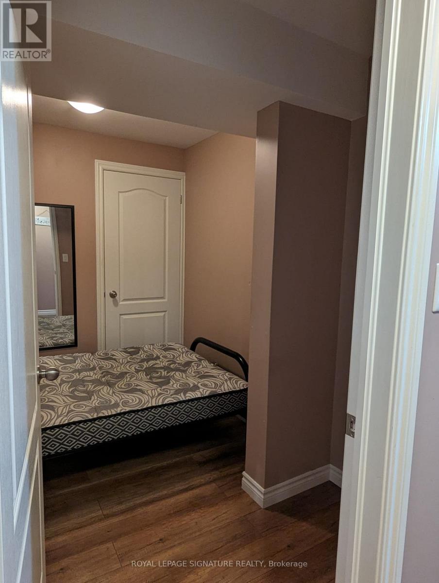 A bedroom with a bed, dresser and mirror.