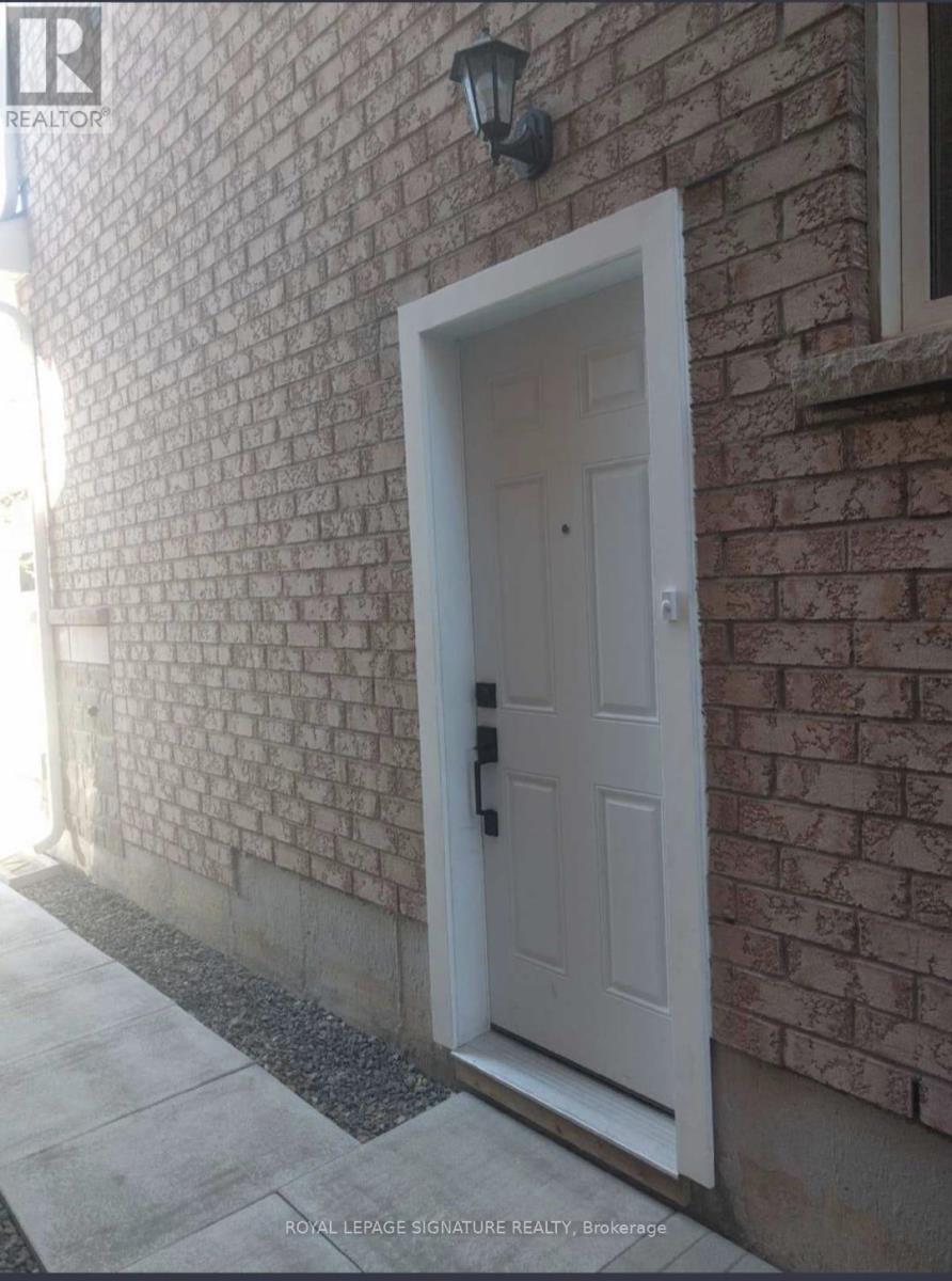 A white door with a black handle is set in a brick wall.