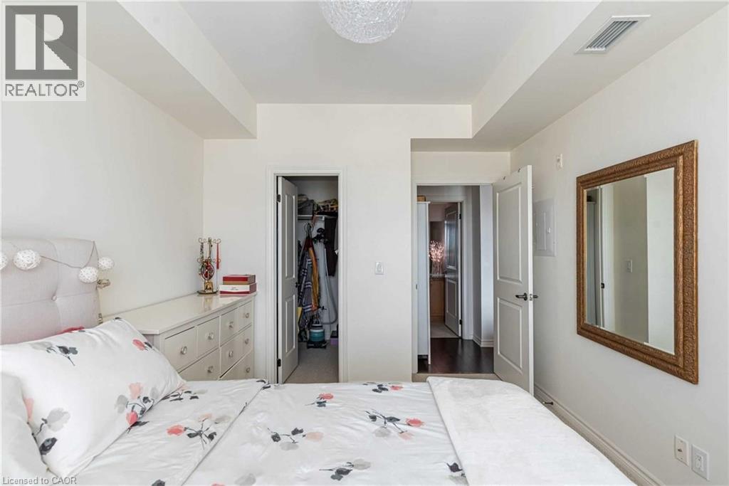 A bedroom with a large bed and a mirror on the wall.