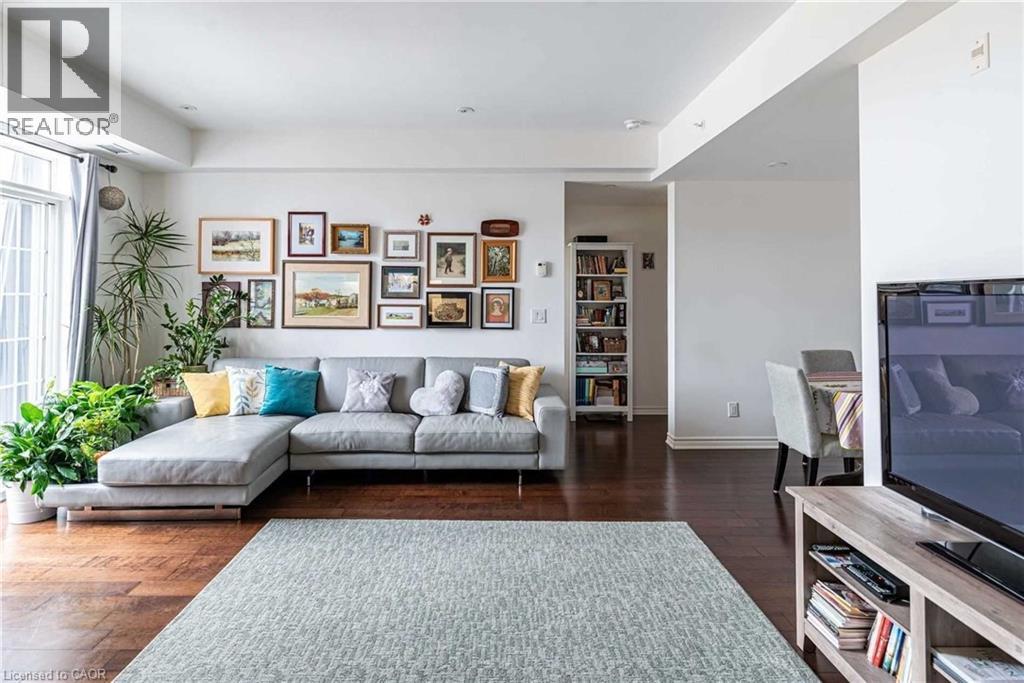 A living room with a grey couch and a green rug.