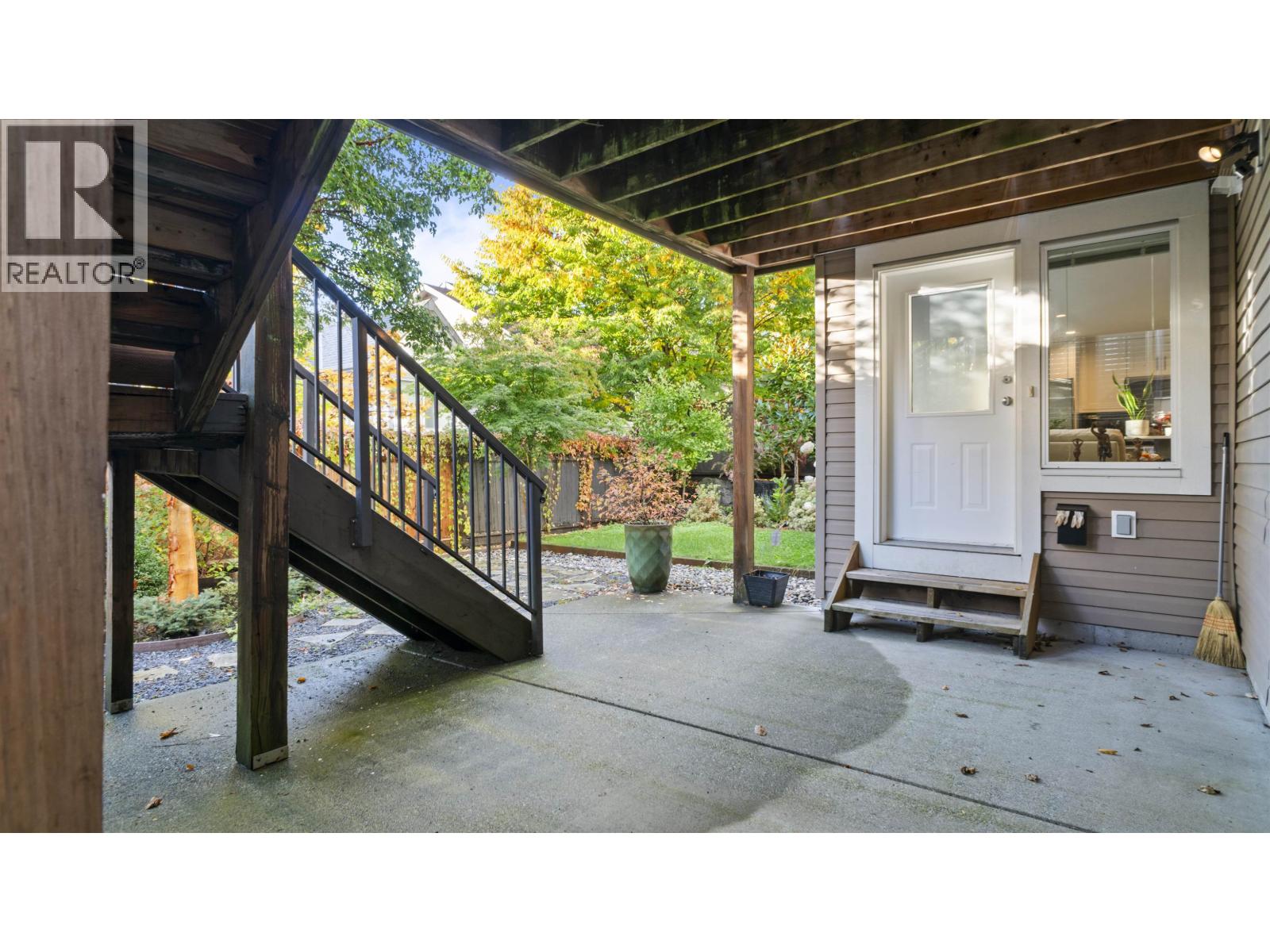 A wooden deck with a metal railing and a white door.