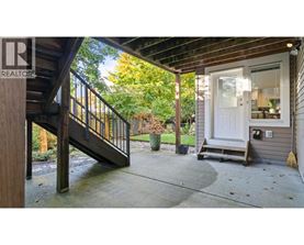 A wooden deck with a metal railing and a white door.