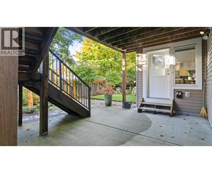 A wooden deck with a metal railing and a white door.