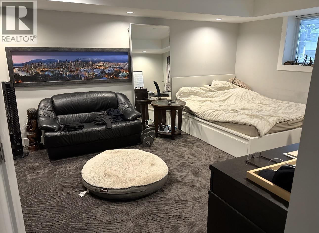 A bedroom with a bed, a couch, and a chair.