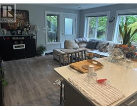 A kitchen with a table and a couch in the background.