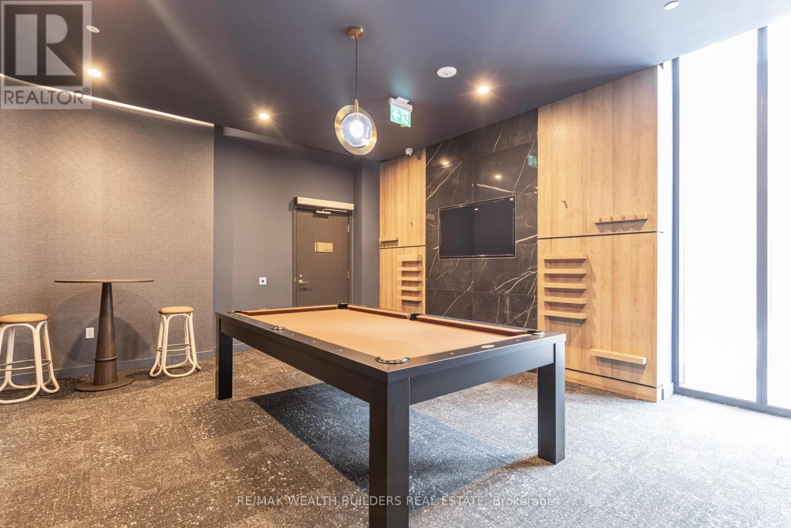 A room with a pool table and a bar area.