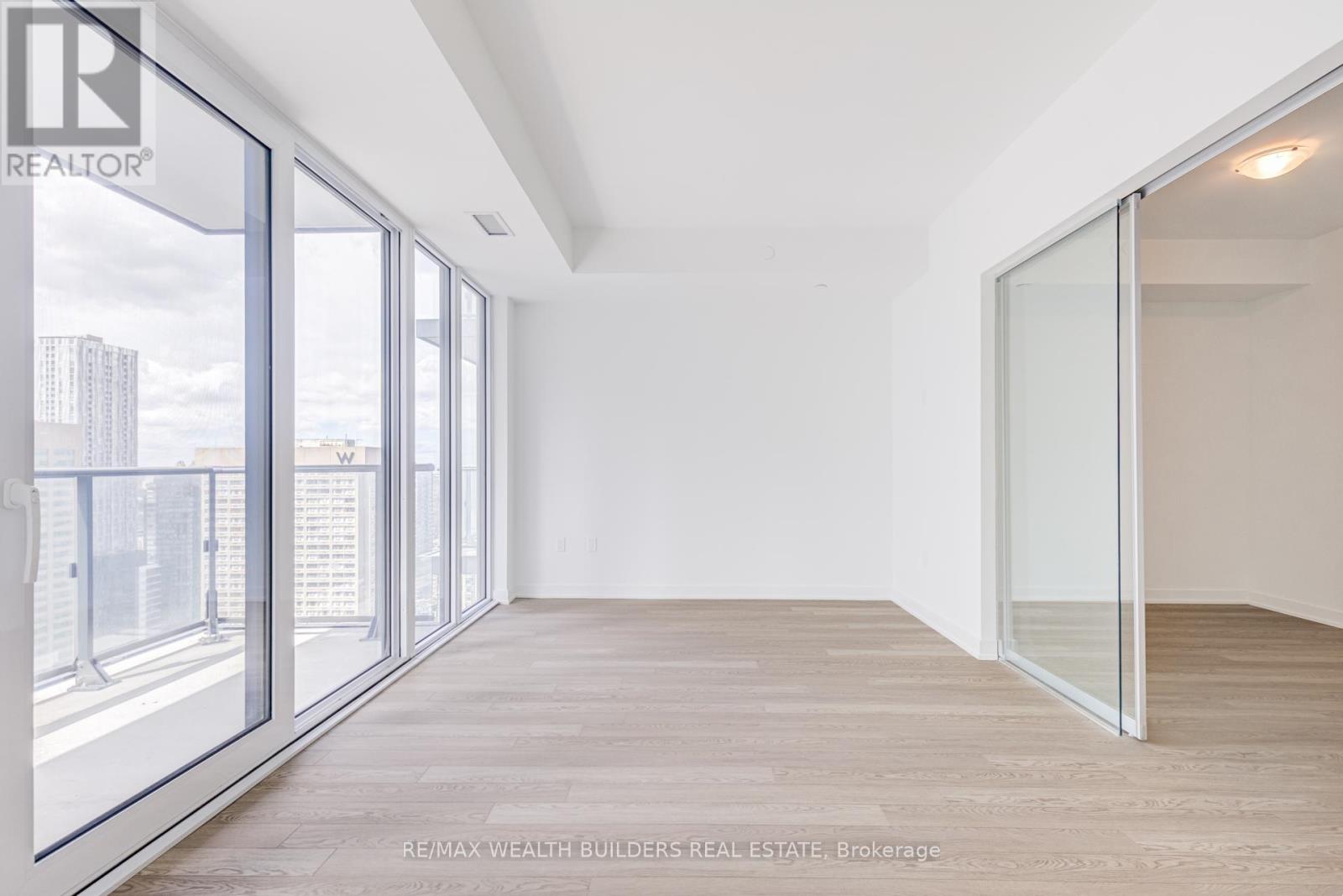 A spacious room with a view of the city through large windows.