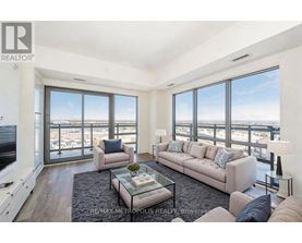 A living room with a couch, a coffee table, and a large window overlooking the city.