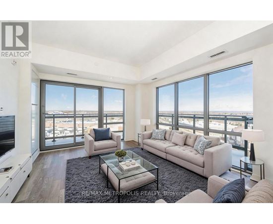 A living room with a couch, a coffee table, and a large window overlooking the city.