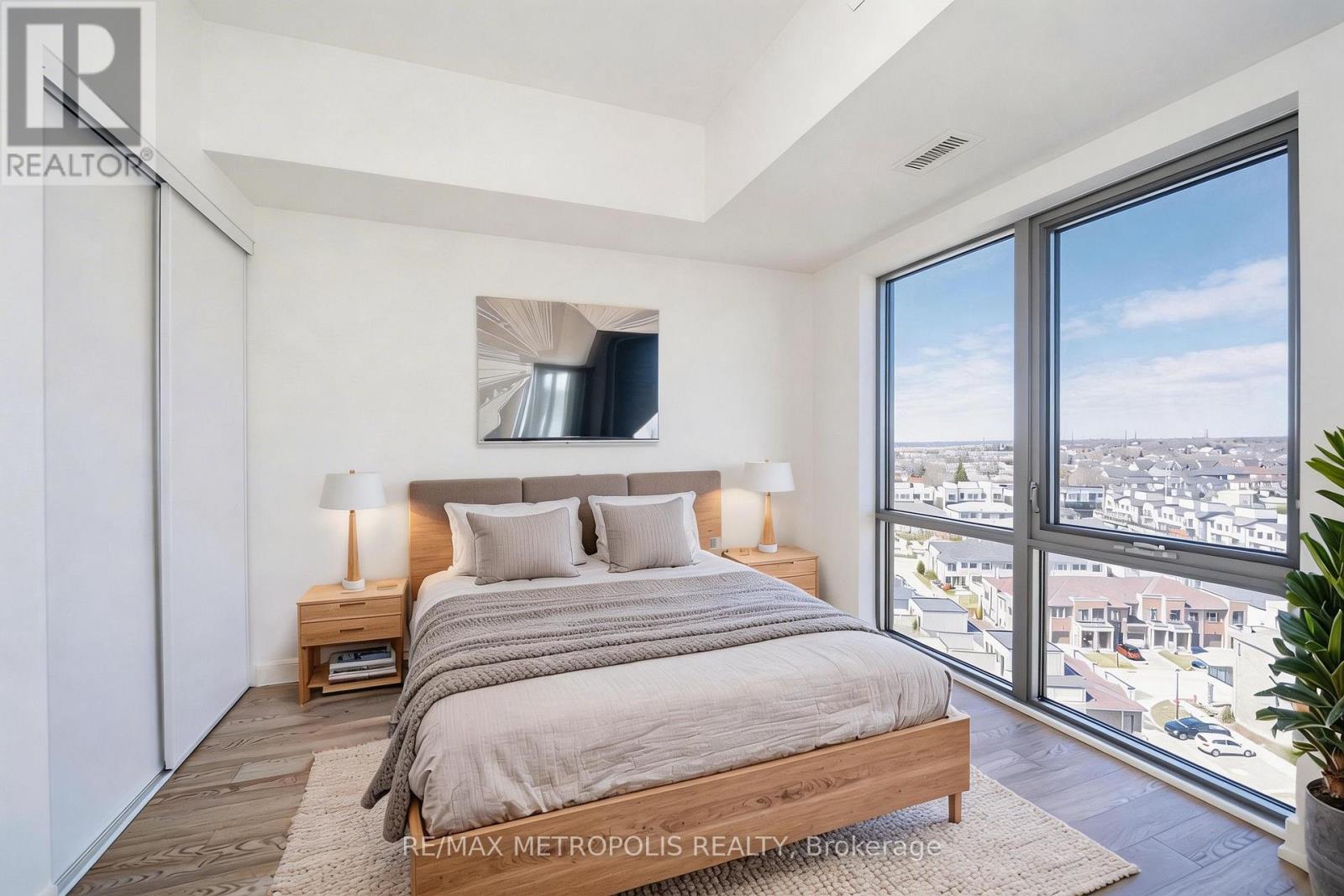A bedroom with a large bed and a view of the city.