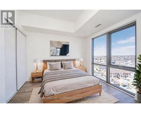 A bedroom with a large bed and a view of the city.