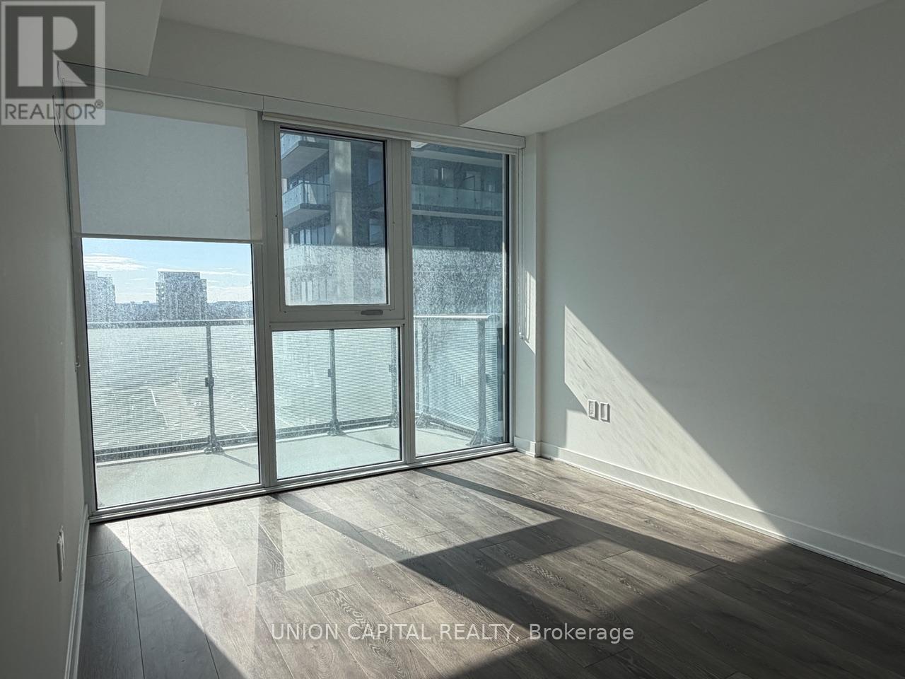 A room with a sliding glass door leading to a balcony.