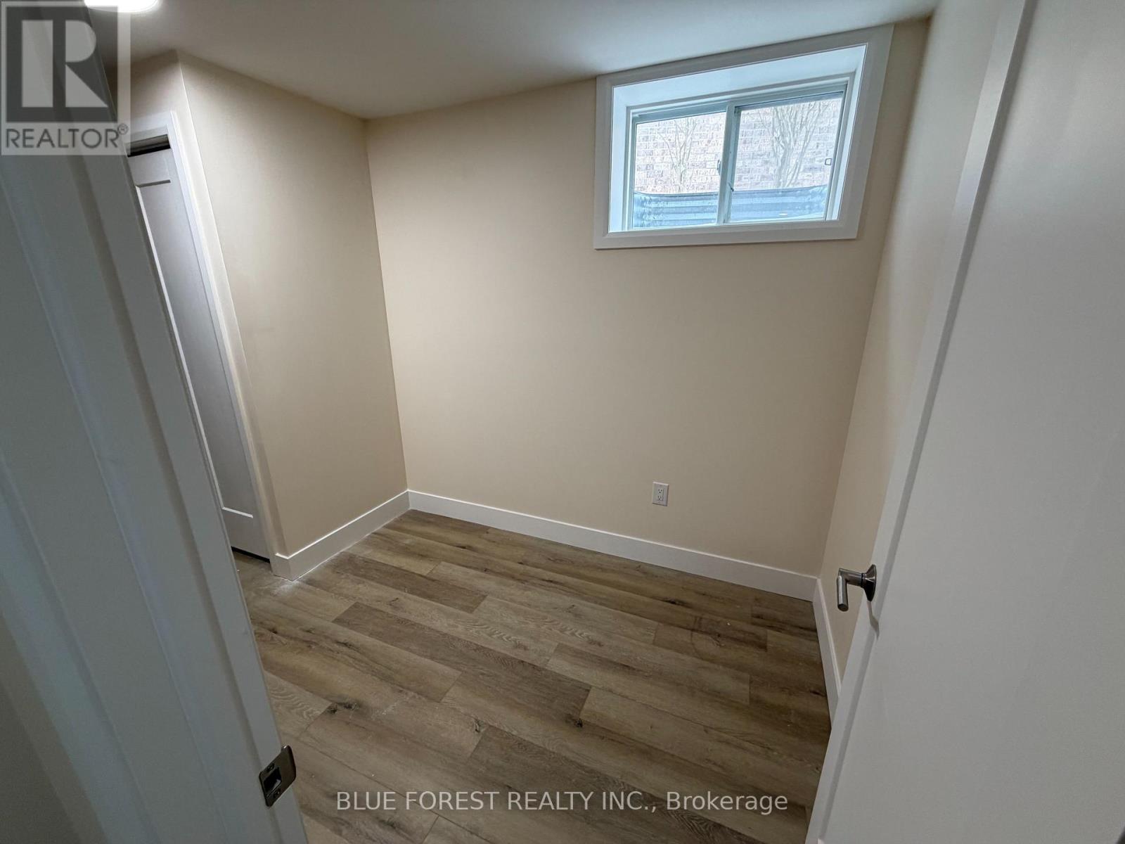 A room with a window and wooden flooring.