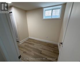 A room with a window and wooden flooring.