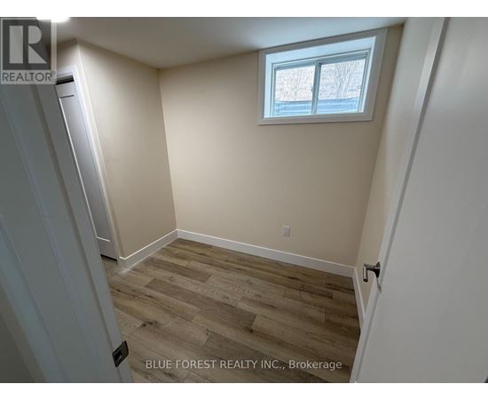 A room with a window and wooden flooring.