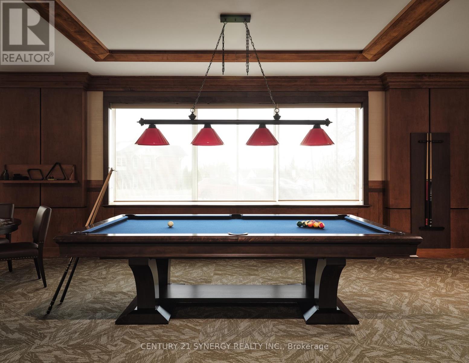 A pool table in a room with wooden walls and a window with blinds.