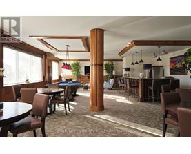 A room with a pool table and a bar area.