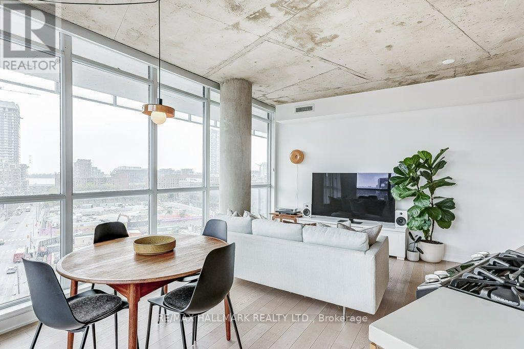 A modern living room with a dining table and a view of the city.