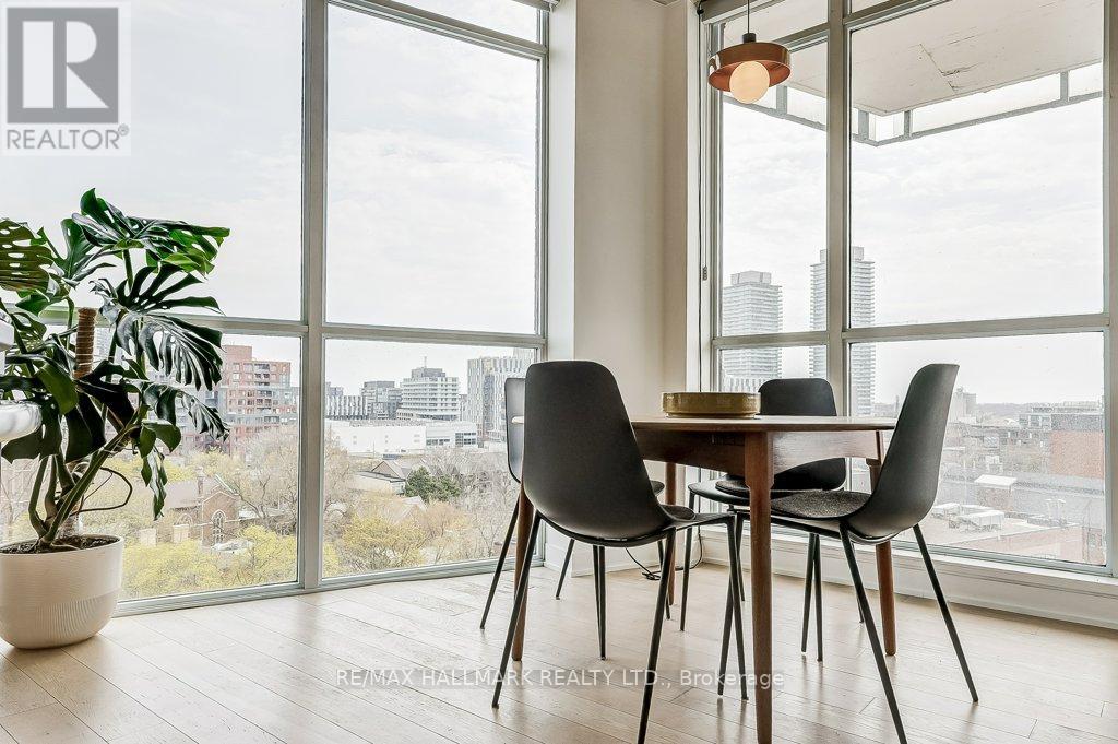 A dining room with a table and chairs and a plant.