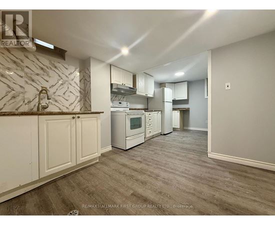 A kitchen with white cabinets and a marble backsplash.