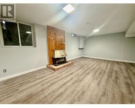 A room with a wood panelled wall and a wood floor.