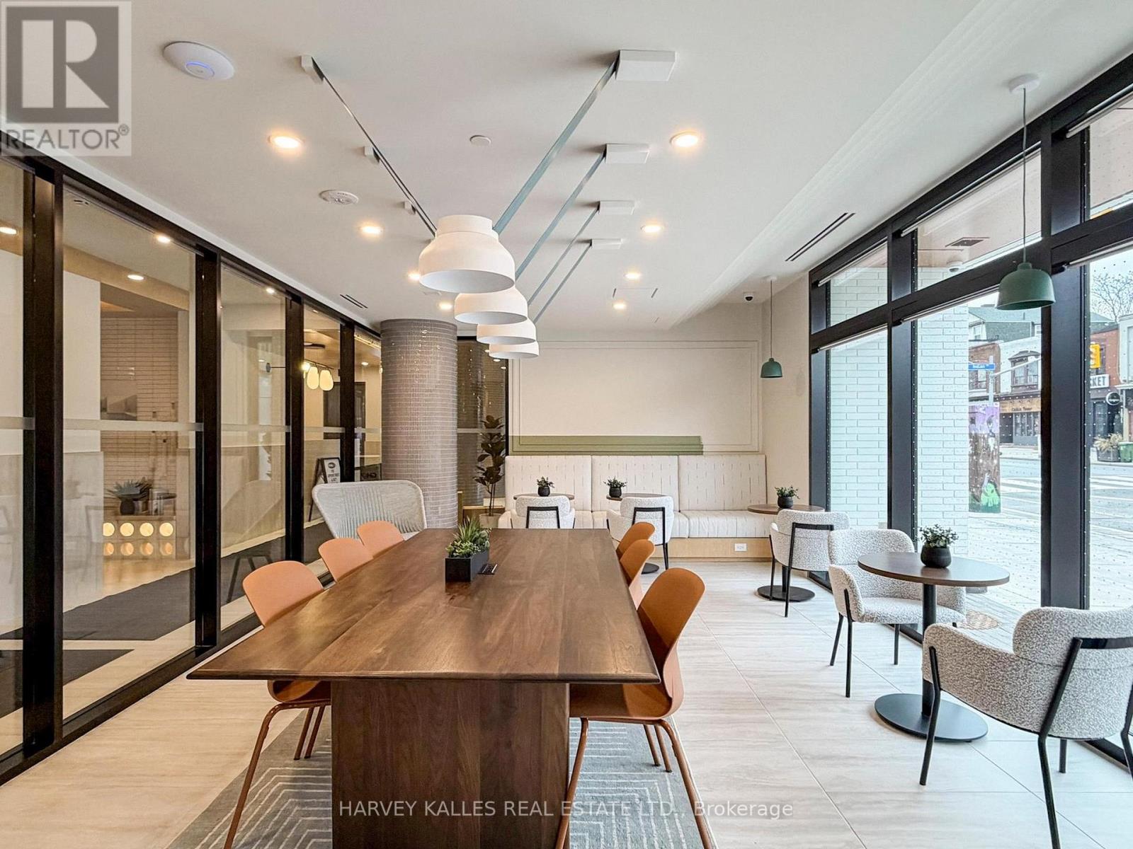 A modern dining room with a long wooden table and chairs.