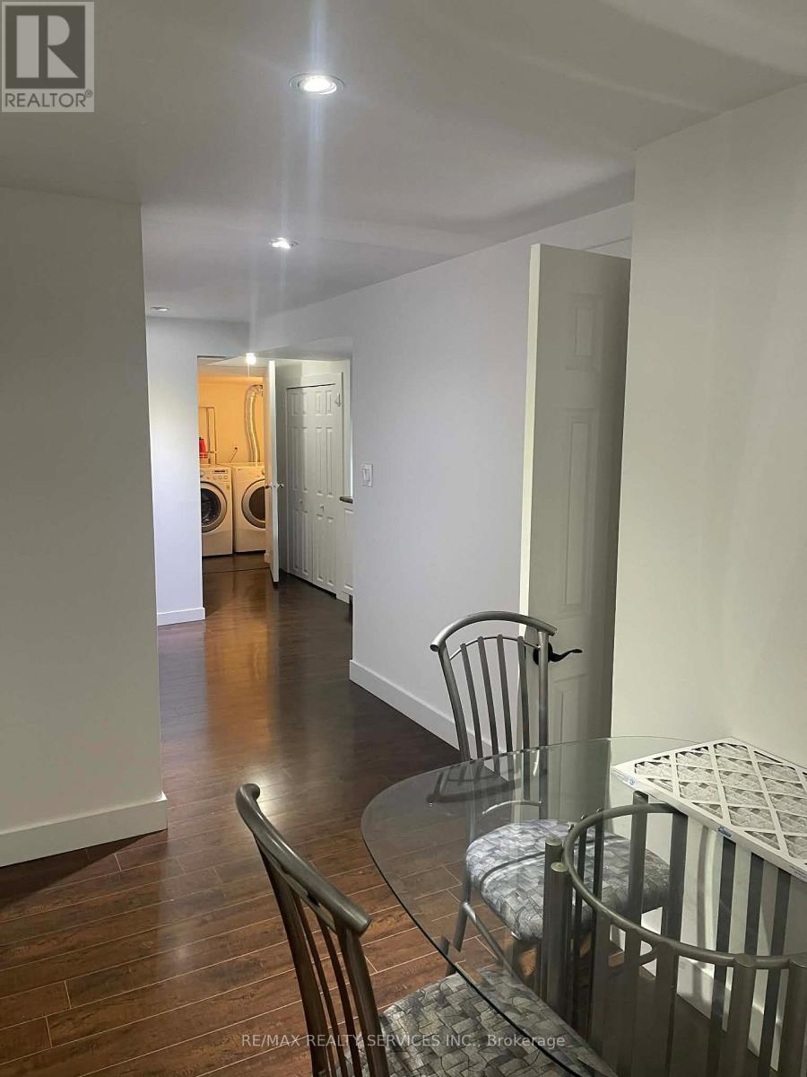 A hallway with a glass table and chairs.