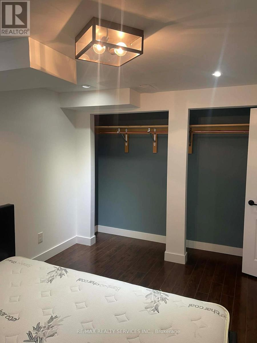 A bedroom with a bed, a ceiling light, and a door.