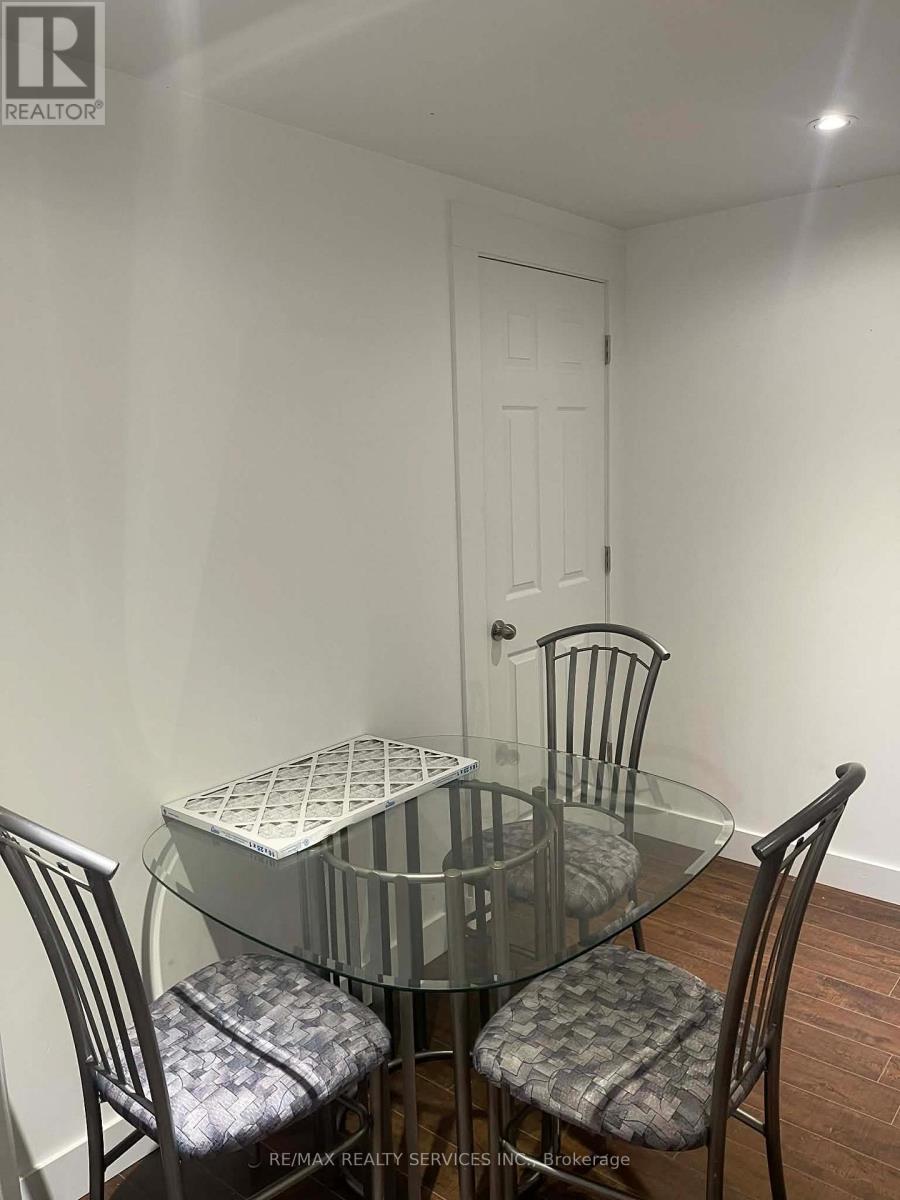 A glass dining table with four chairs around it.