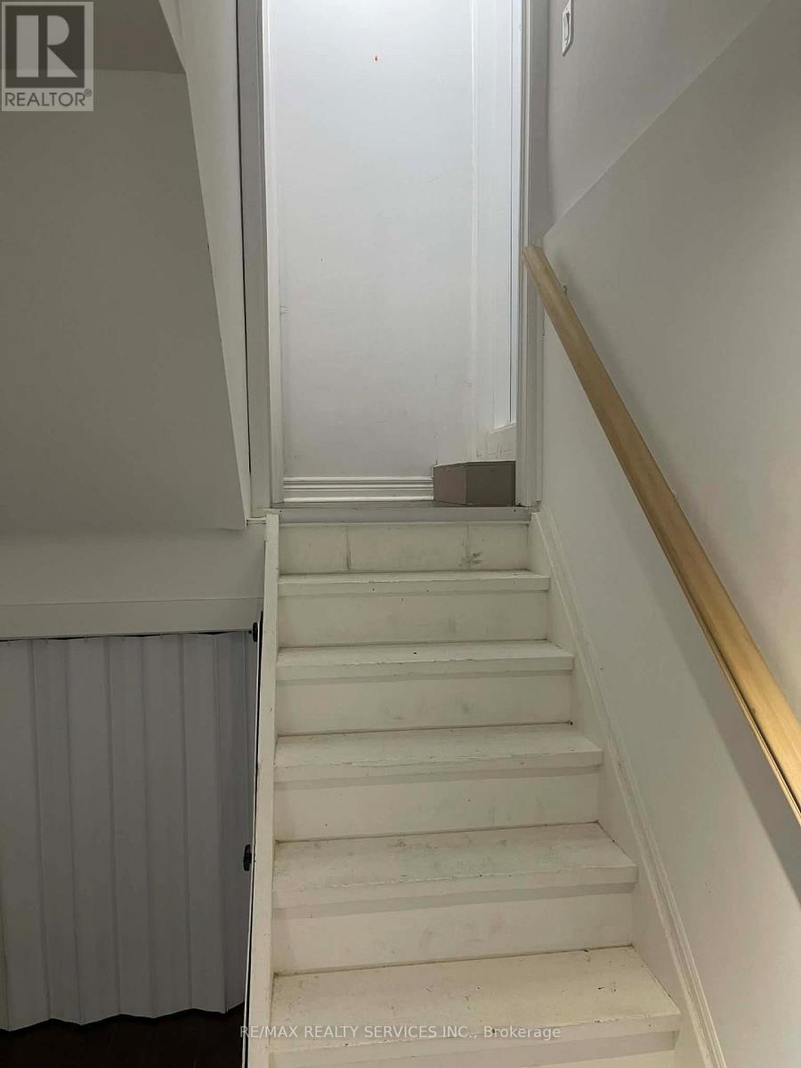 A staircase with a wooden handrail and white steps.