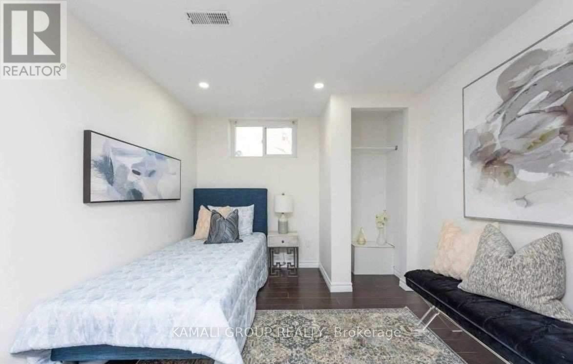 A bedroom with a bed, a couch, and a painting on the wall.