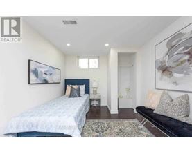 A bedroom with a bed, a couch, and a painting on the wall.
