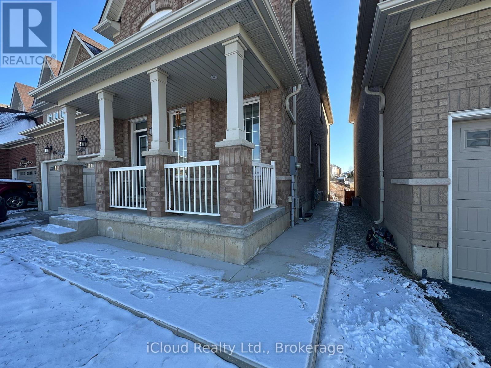 A house with a porch and snow on the ground.