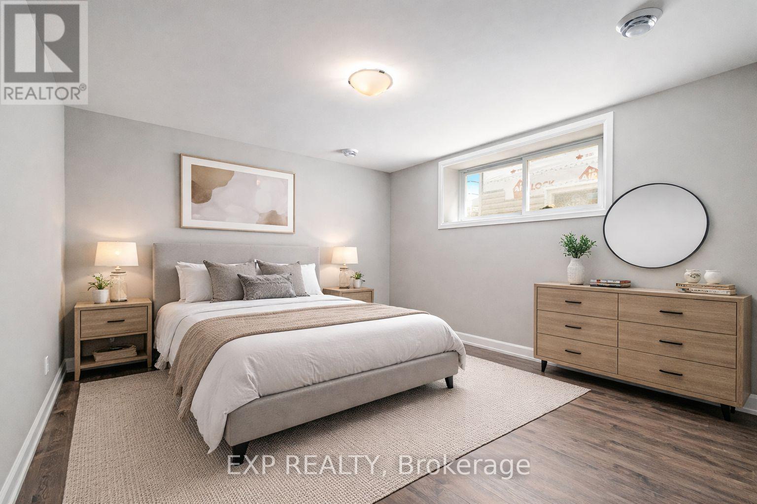 A bedroom with a large bed, a dresser, and a nightstand with lamps.