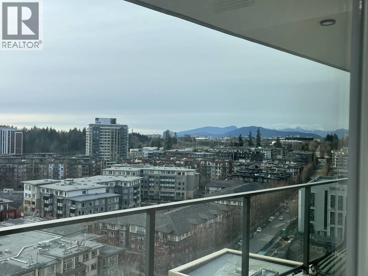 A view from a balcony overlooking a city with buildings and a mountain in the distance.