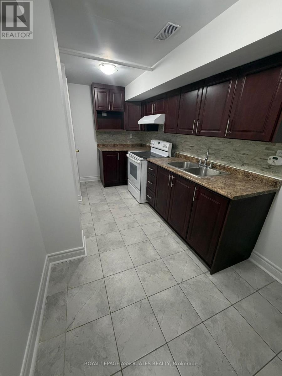 A kitchen with white appliances and brown cabinets.