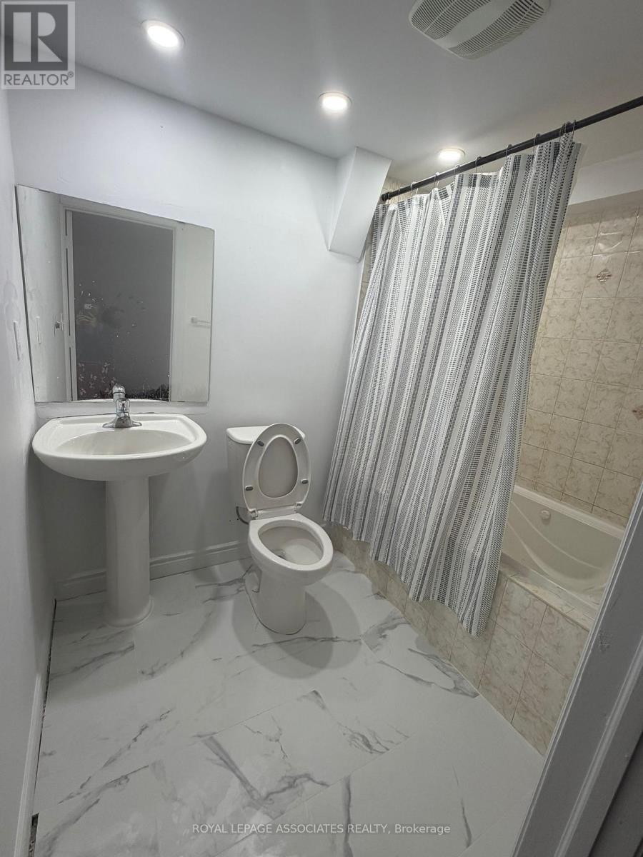 A white bathroom with a sink, toilet and shower.