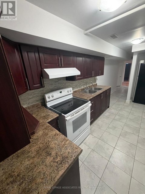 A kitchen with brown cabinets and a white stove top oven.