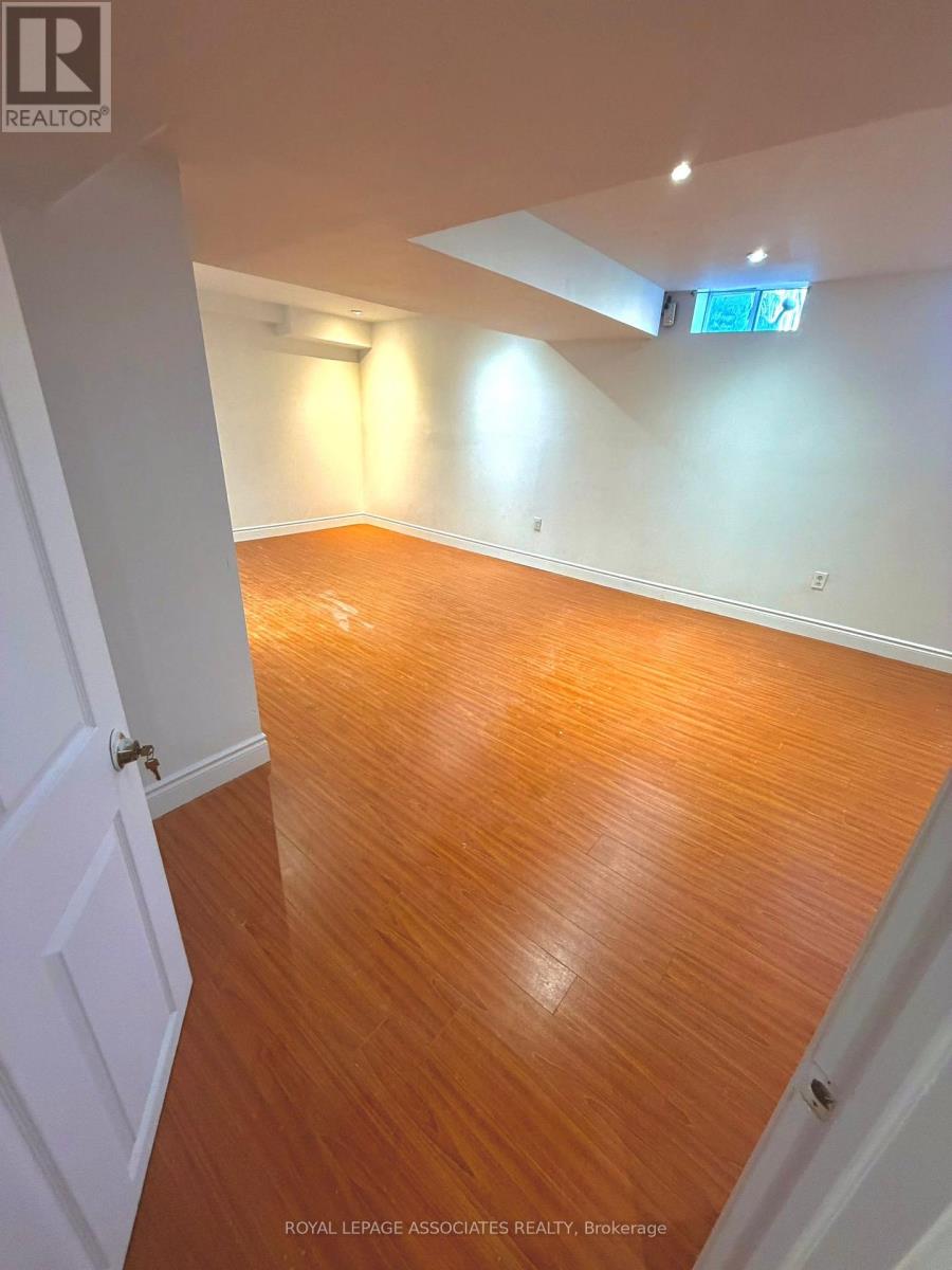 A room with wooden flooring and white walls.